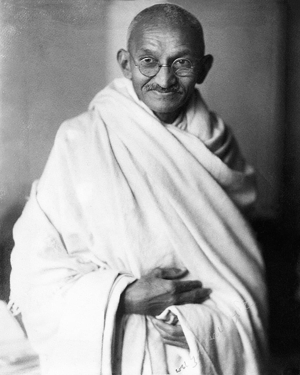 Schwarz-Weiß-Aufnahme von Mahatma Gandhi mit runder Brille und weißem Tuch