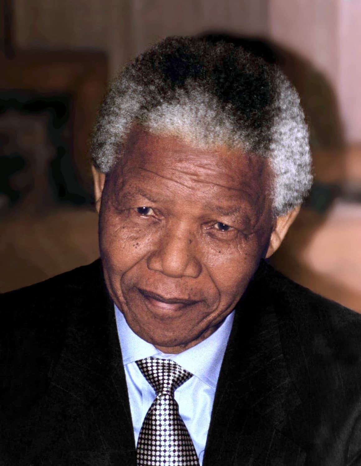 Farbporträt von Nelson Mandela mit grauem Haar, dunklem Anzug und karierter Krawatte